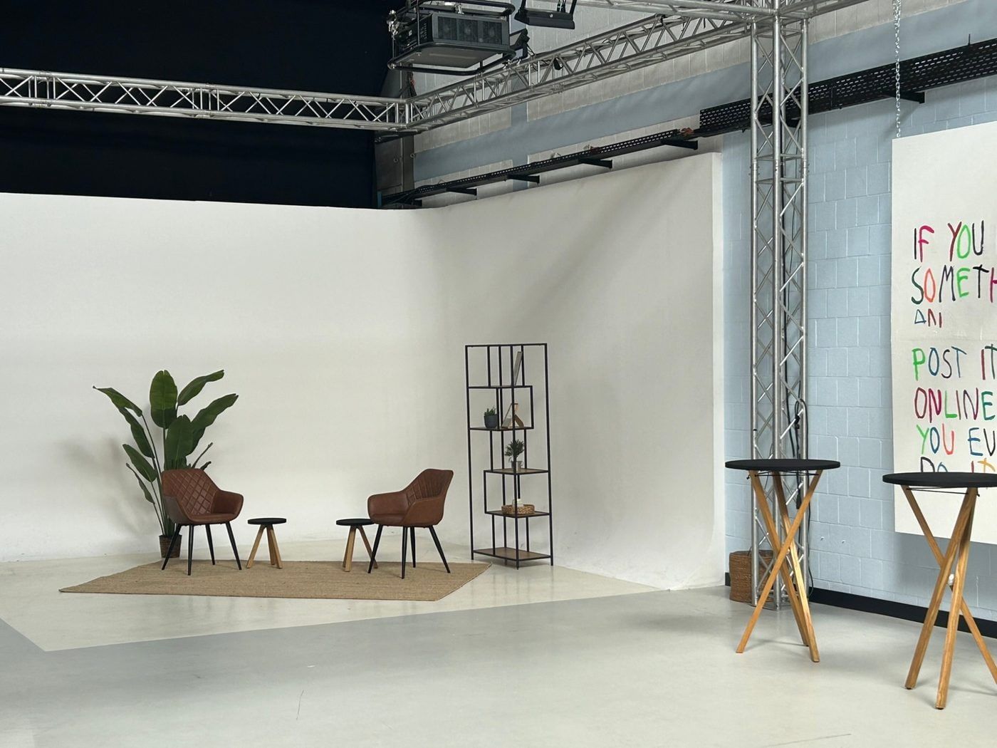 Weiße Hohlkehle im Bauwerk Studio in Köln mit zwei braunen Sesseln, Pflanze und Regal für ein Interview