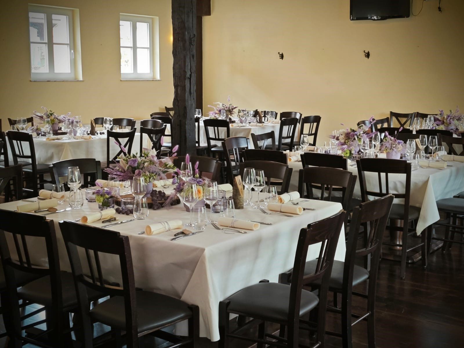 Festlich eingedeckte Hochzeitstische mit Lavendel und Weingläsern im Saal des Weilerhofs in Hürth