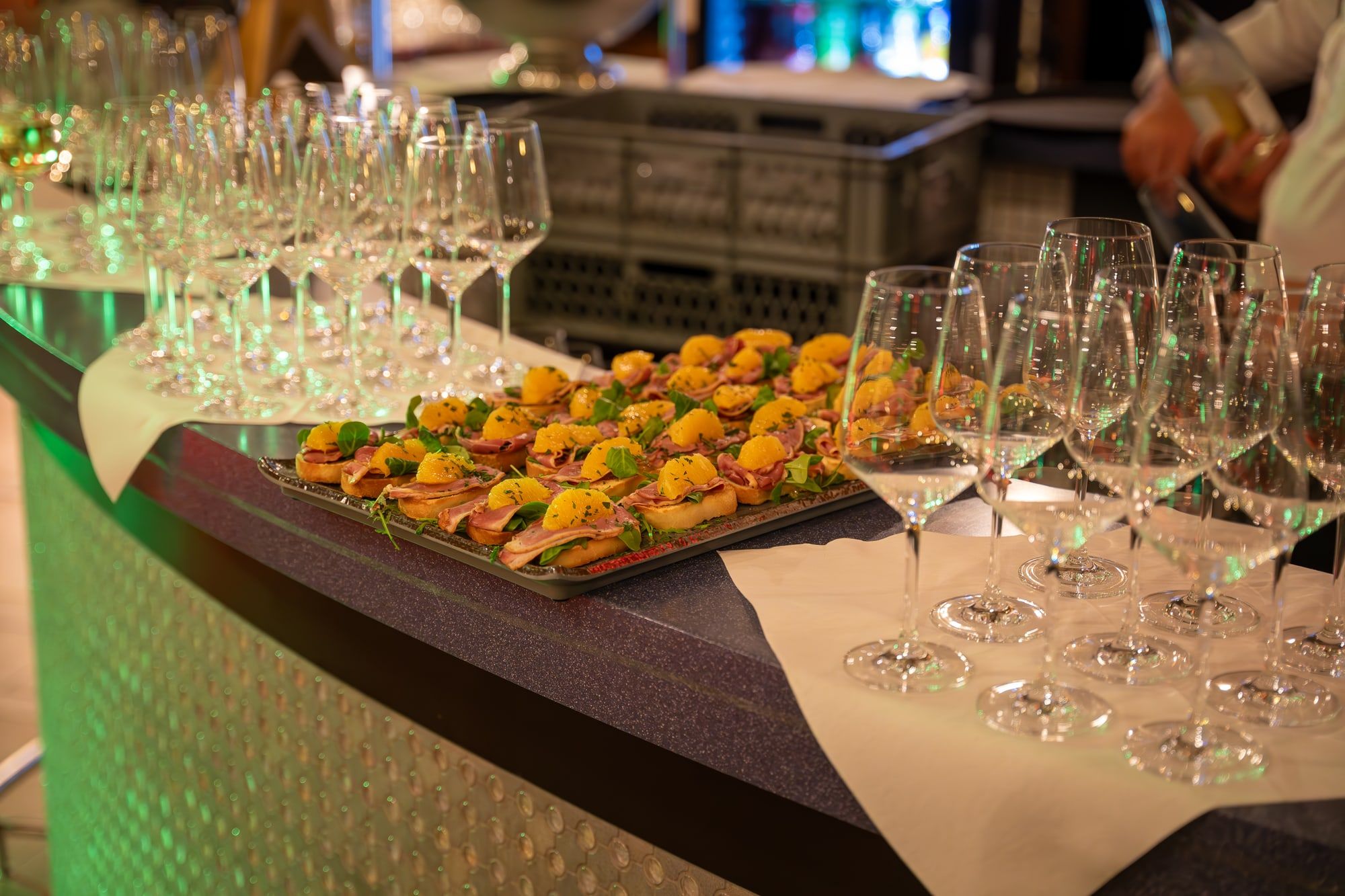 Canapés auf einem Tablett an der Bar der Rotunde, daneben Reihen von Weingläsern für den Empfang