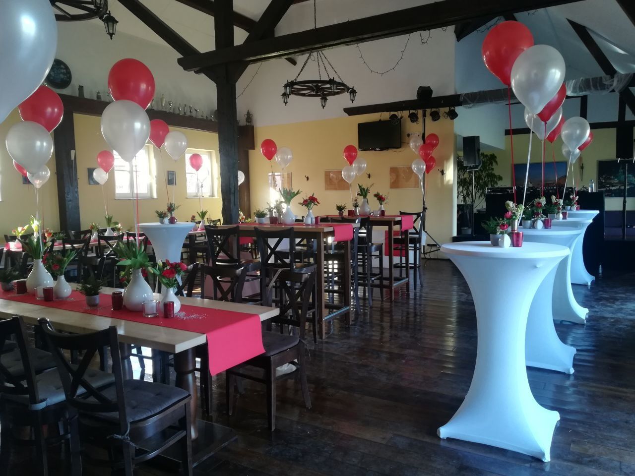 Geburtstagsfeier im Saal des Weilerhofs mit roten und weißen Ballons und hohen Stehtischen